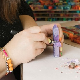 Nicole hand-carving a crayon letter in her studio
